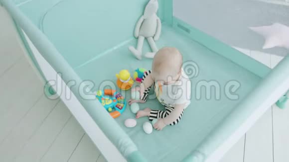 幼儿在家中的玩具围栏里咬玩具鸡蛋视频的预览图
