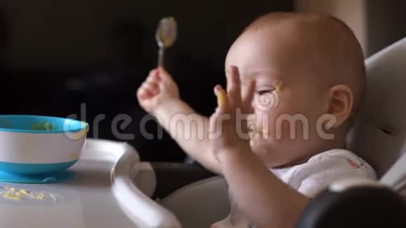 小可爱的男孩开心地用手吃着婴儿粥真诚地微笑着视频的预览图