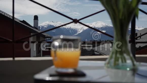在风景如画的山景中女性手拿着一杯新鲜橙汁视频的预览图