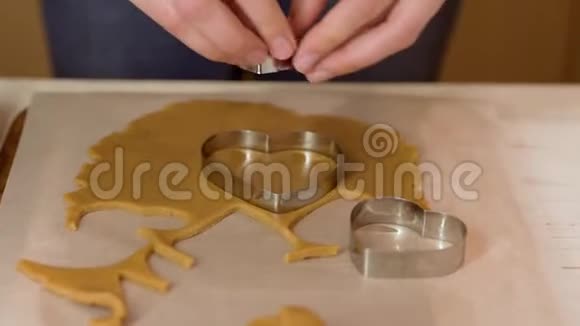 女人在桌上用心形刀切姜饼面团视频的预览图