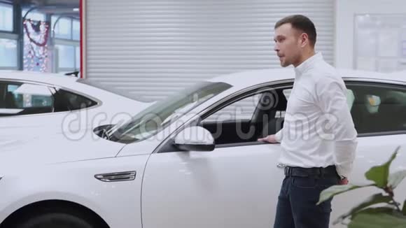 男子手把车钥匙交给男子手在汽车经销店关门汽车销售商和一个买车的男人视频的预览图