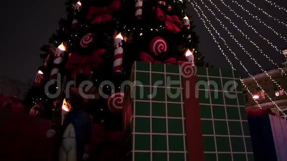 夜空背景上的圣诞树灯和装饰品概念云杉树的底部景观有蜡烛和视频的预览图