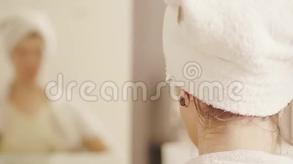 女人头上的毛巾对着镜子摘下耳环视频的预览图