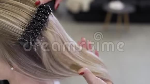理发师给女孩做头发美容院的金发美女视频的预览图