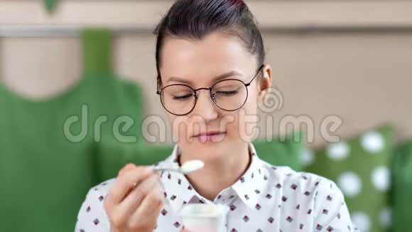 近距离休闲女性戴眼镜吃天然酸奶情绪积极视频的预览图