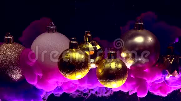 金色闪亮的圣诞球黑色背景下的紫罗兰色墨水视频的预览图