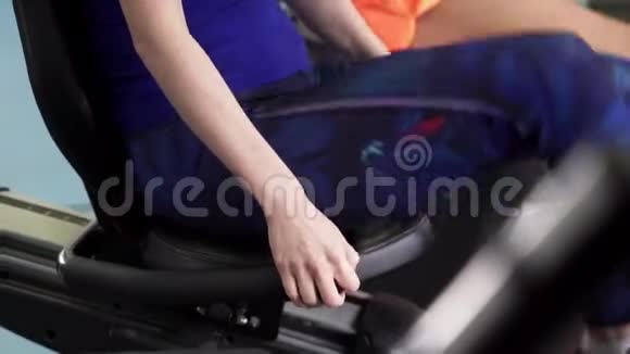 运动女性的腿在健身房的固定周期做有氧运动视频的预览图