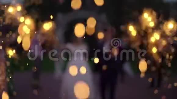 抽象模糊人们在街上点燃火花庆祝婚礼有灯光的浪漫夜晚视频的预览图