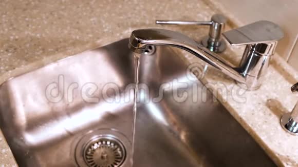 水从厨房水龙头流入金属水槽概念干净的水从厨房的铬水龙头流出视频的预览图
