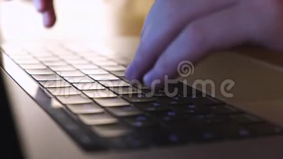 特写男性手在笔记本电脑键盘上打字蓝色照明概念在电脑上工作视频的预览图