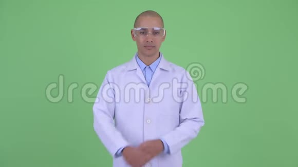 快乐秃顶多民族医生戴着防护眼镜双臂交叉微笑视频的预览图