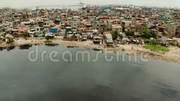 马尼拉港口附近的贫民窟贫穷居民的住房向海洋中释放垃圾视频的预览图