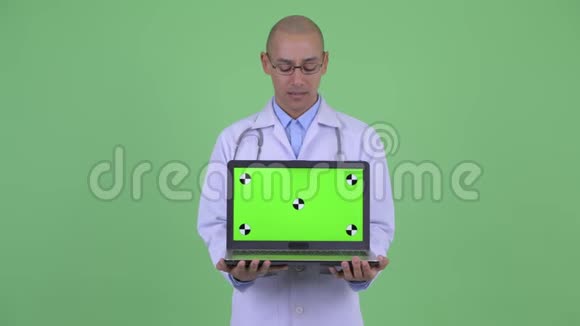 戴着帽子的多民族医生带着笔记本电脑视频的预览图