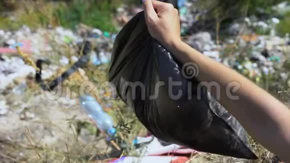 在森林生态系统中妇女用手扔垃圾袋视频的预览图