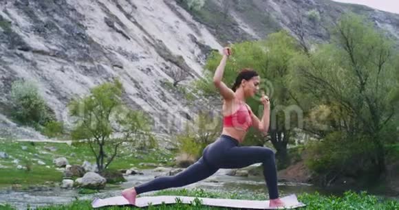 运动的女士穿着舒适的运动服练习瑜伽她在垫子上伸展全身视频的预览图