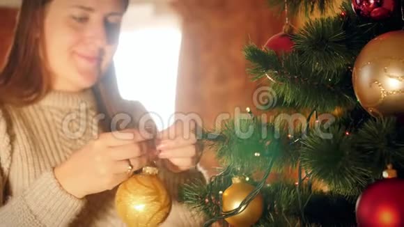 美丽微笑的年轻女子在圣诞树上放子和球视频的预览图