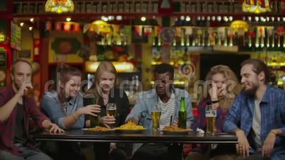 周末朋友在啤酒店喝啤酒与年轻人一起玩的友谊概念视频的预览图