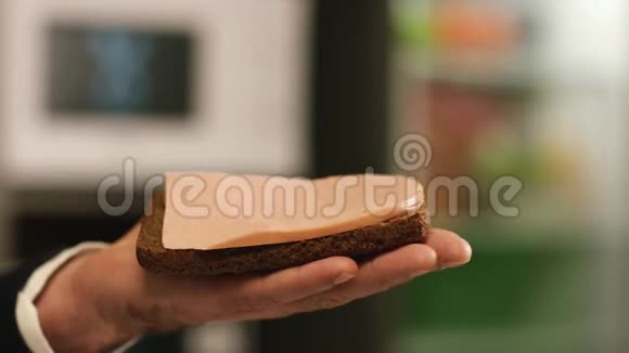 男人的特写手拿着一块博罗迪诺黑麦面包上面夹着医生香肠库存数据视频的预览图