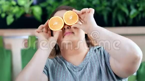 滑稽的肥胖节食女人的肖像半个橙色覆盖眼睛中等特写视频的预览图