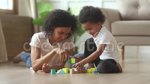 非洲母亲的儿子在地上玩玩具积木视频的预览图