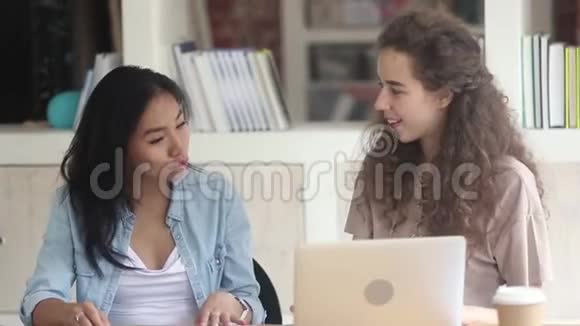 不同的学生女孩坐在教室里的桌子上说话视频的预览图