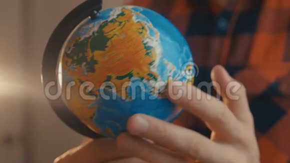 年轻男性持有地球仪一个人旋转一个地球仪并指向它旅行概念视频的预览图