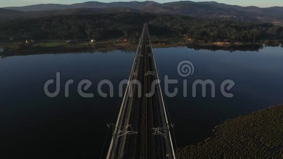 从无人驾驶飞机在日落光线下拍摄跨河大桥的空中景色视频的预览图