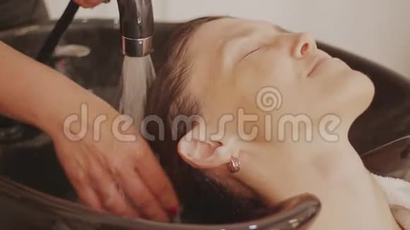 理发师为女性洗头用洗发精按摩头皮视频的预览图
