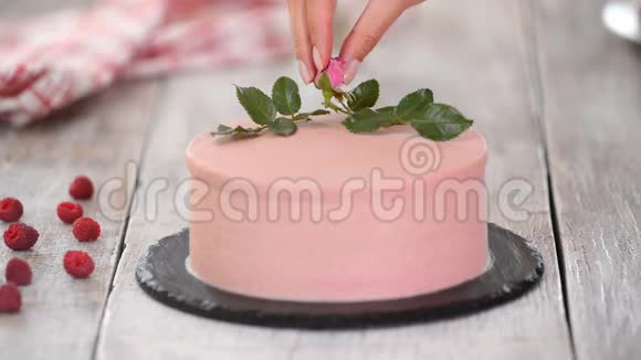 糖果师用玫瑰装饰粉红色蛋糕视频的预览图