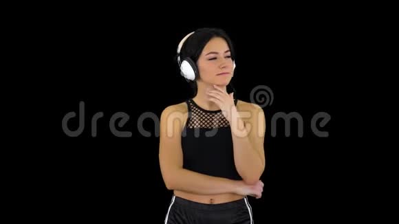 年轻的运动美女戴着耳机欣赏音乐阿尔法频道视频的预览图
