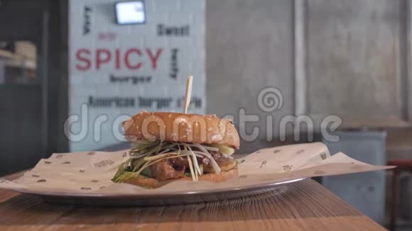 一个男人从木条上拿着一个盘子和一个多汁汉堡的特写镜头一个男人拿着一个盘子和一个汉堡4k4k视频缓慢的视频的预览图