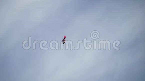 玩具球飞在蓝天的背景上行动玩具形状的单凝胶球在蓝天上飞得很高有人放手了视频的预览图