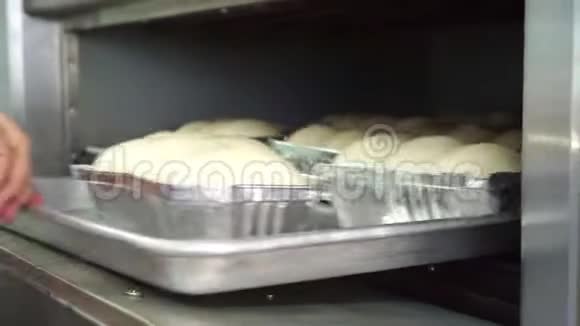 厨师用一盘面包面团放入烤箱视频的预览图