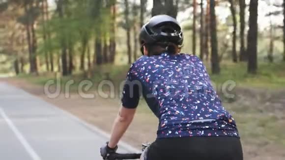 适合白种人的三项运动员女孩在公园里骑自行车关上踏板腿部肌肉收拢铁人三项的概念视频的预览图