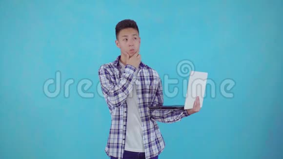 体贴的亚洲年轻人用蓝底笔记本电脑找到解决方案视频的预览图