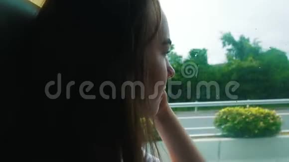 一个年轻的女人坐在公共汽车里看着窗户视频的预览图