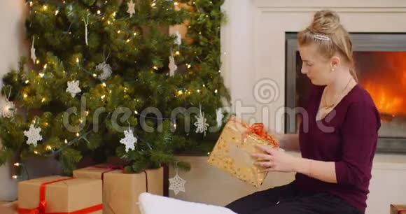 女人把圣诞礼物放在树下视频的预览图