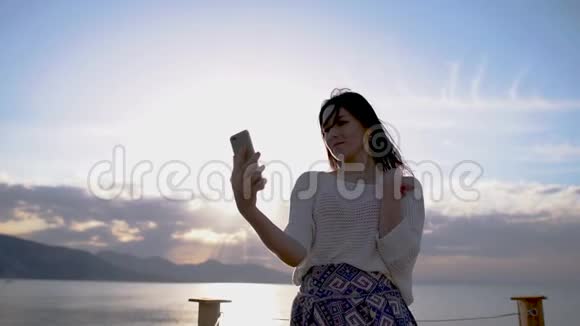 日落时分女模特在智能手机上拍了一张照片视频的预览图