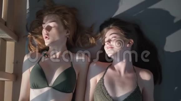 女朋友休息穿着泳衣的年轻女性在暑假期间在豪华的海边平房里玩得开心视频的预览图