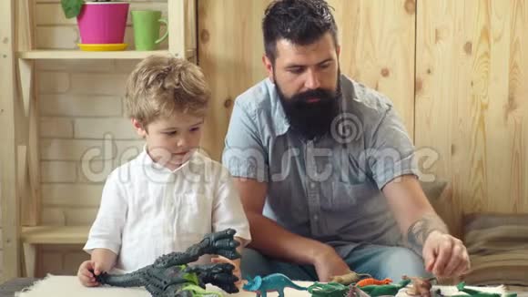 父亲和他的孩子在家玩父亲节快乐家庭幸福玩的时间孩子和胡子男在玩视频的预览图