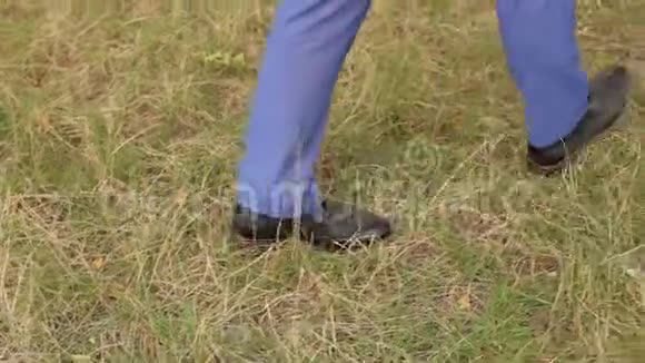 一个穿西装和棕色皮鞋的商人的特写在草地上视频的预览图