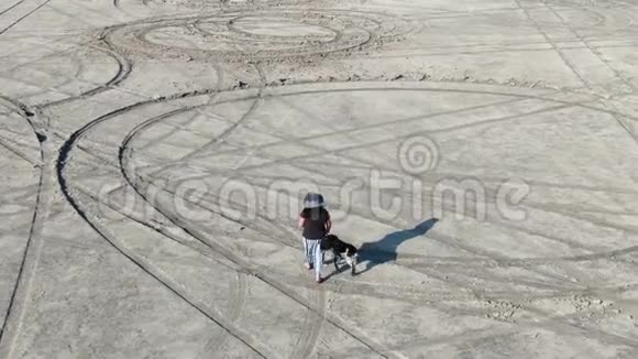 沙漠中央有条狗的女人空中无人驾驶飞机视频的预览图