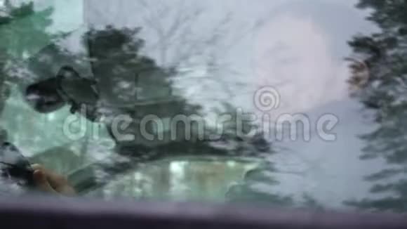 开车的人看着车窗外在雪道上开车的年轻人视频的预览图