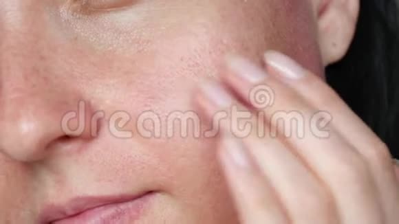 皮肤质地毛孔扩大一个女人摸她的脸做按摩特写问题护肤抗衰老视频的预览图
