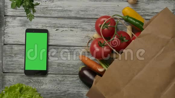 番茄在蔬菜和智能手机附近滚动视频的预览图