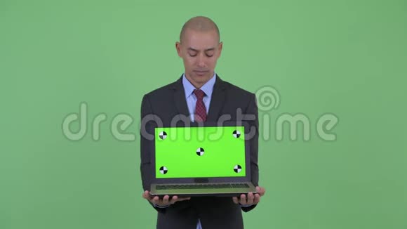 一位戴着笔记本电脑的秃头多民族商人视频的预览图