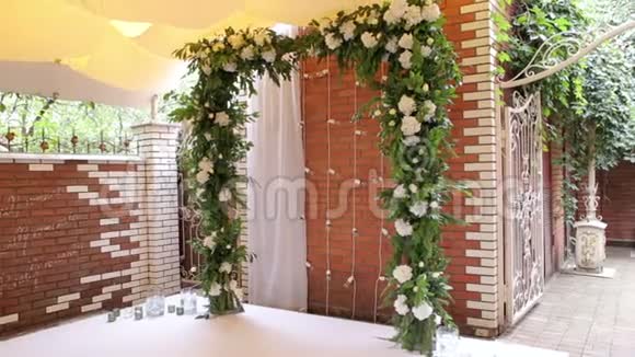 婚礼拱门白色的花靠在砖墙上视频的预览图