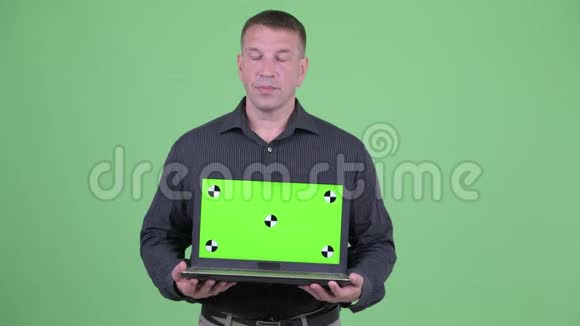 大男子主义成熟商人一边展示笔记本电脑一边思考视频的预览图