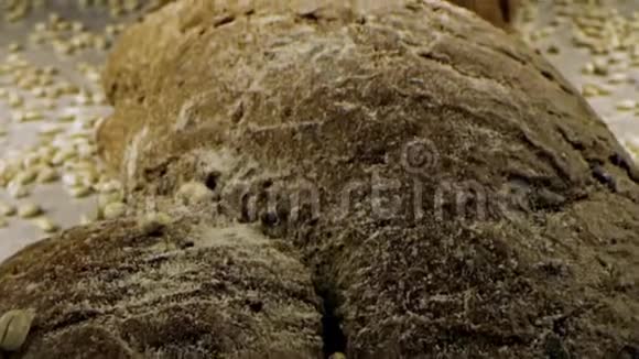 新鲜面包上的谷物库存录像谷物倒在新鲜的自制面包上视频的预览图