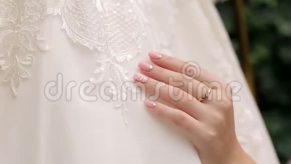新娘的特写欣赏她漂亮的婚纱视频的预览图